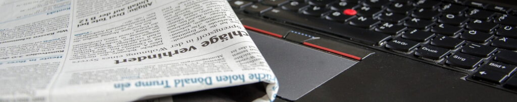 Symbolfoto für Neuigkeiten, Zeitung liegt auf Notebook